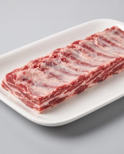 Lamb Breast — Cut Off — A narrow trimmed strip of lamb breast rib tips, thin alternating layers of fat and meat