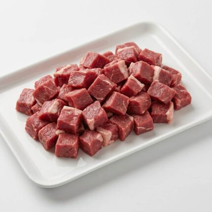 Raw diced lamb leg meat on a white tray