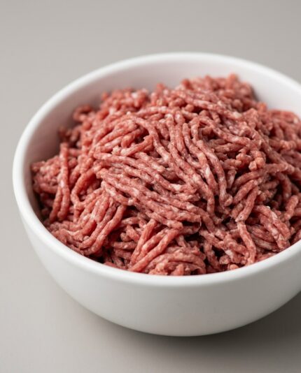 Lamb Legs — Minced — A bowl of finely minced lamb leg meat, loose lean reddish-pink strands with minimal visible fat