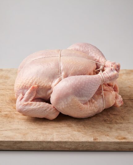 Whole Chicken 1200 — A smaller whole raw chicken with a slim rounded breast and neatly folded legs, trussed for roasting